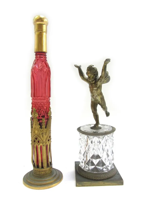 A 19th century Gothic Revival gilt bronze mounted cranberry glass scent bottle, the base in the form of a reliquary, 31cm high, and a gilt bronze wing