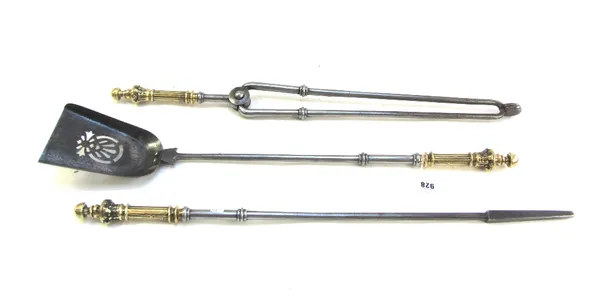 A set of Victorian steel and brass handled fire irons, with knopped stems and a pierced shovel plate, 71cm long (3).