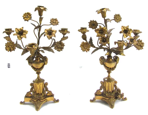 A pair of 19th century gilt metal four branch candelabra, each modelled and cast as still life flowers protruding from a two handled urn, on a fluted