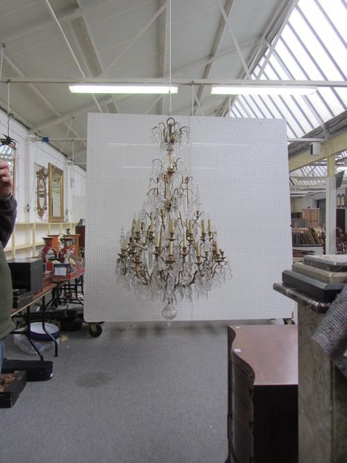 A Louis XV style thirty four branch gilt metal and glass chandelier, early 20th century, with central glass shaped stem issuing three graduated tiers