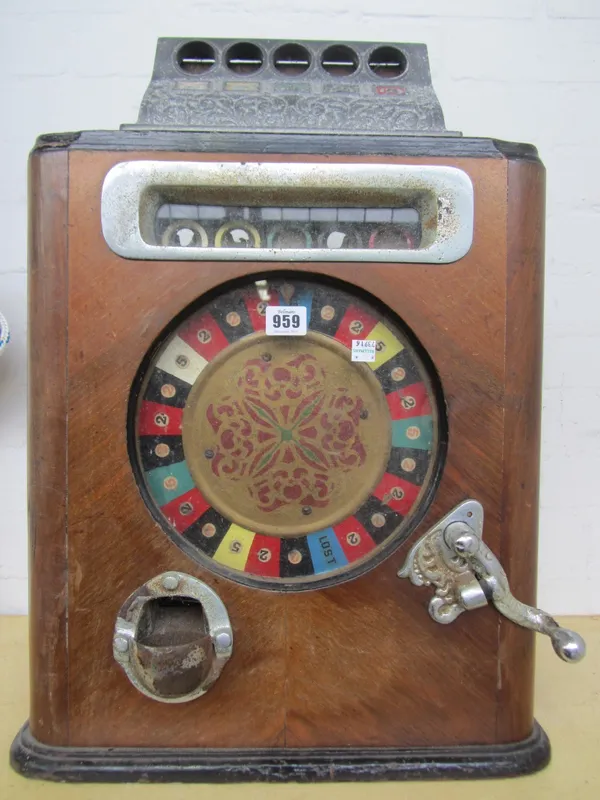 An early 20th century penny slot roulette gaming machine, mahogany cased, with metal hardware and mechanical movement (a.f), 59cm high.