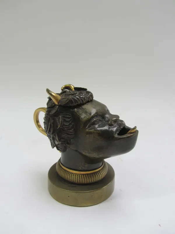 An unusual gilt and patinated bronze figural inkwell, 19th century, modelled and cast as a nubian male wearing a floral wreath with protruding horns,