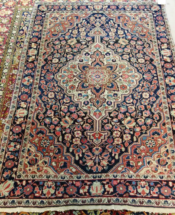 A Sarough rug, Persian, the black field with an ivory and madder medallion, matching spandrels, all with floral sprays, a black complementary border,