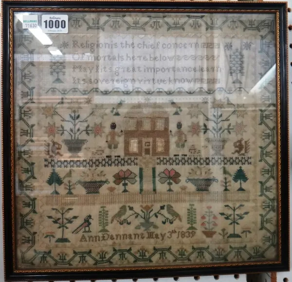 A needlework sampler by Ann Dennant, dated 1839, with religious verse over a house flanked by figures, flowers and birds, within a wide foliate border