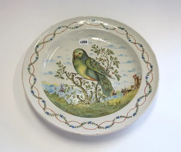 A large Continental faience dish, probably Naples, late 18th century, painted with a bird in branches before ships entering into a harbour with castle
