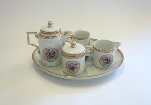 A Berlin (K.P.M) solitaire, circa 1790, underglaze blue sceptre mark, presnummern and incised marks, painted with roses against a gilt bordered white