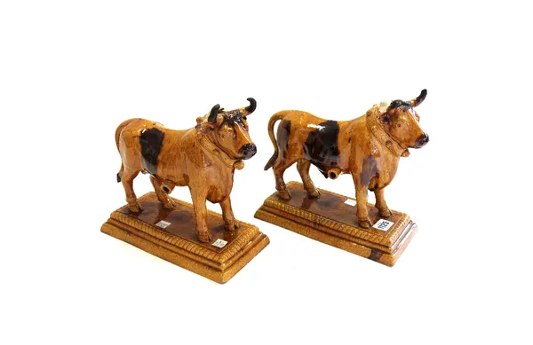Two Mafra pottery bulls, circa 1900, each canister decorated in mottled browns, raised on a plinth base and impressed 'M. Mafra, Caldas Portugal' (a.f