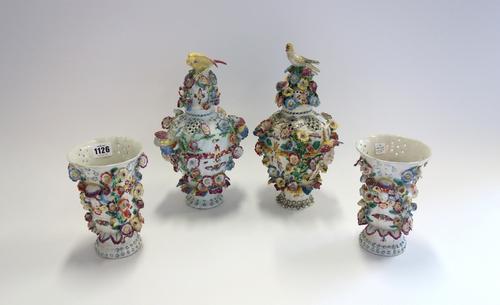 An assembled garniture of Bow pierced frill vases and two covers, circa 1765, comprising two ovoid vases and covers with mask and shell handles, appli