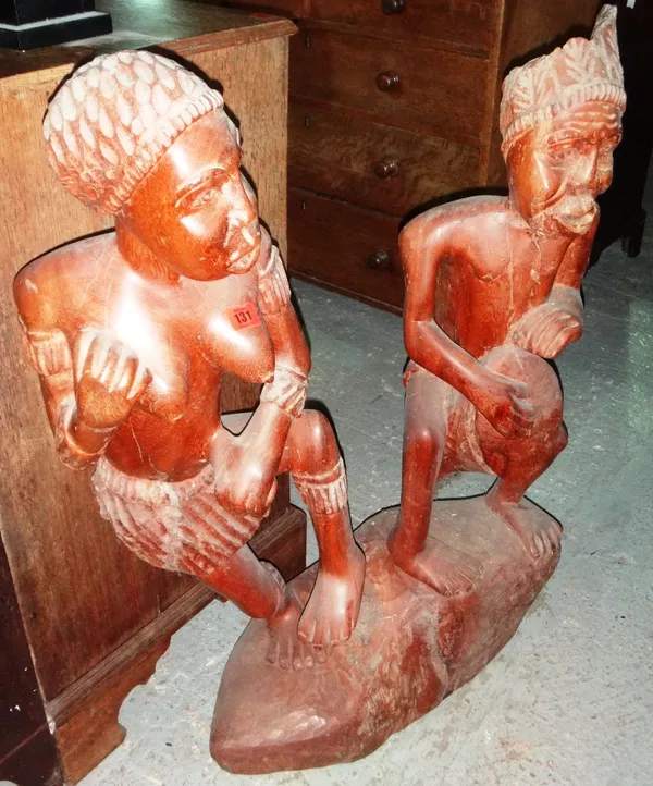 A hardwood carved figure group depicting two people, together with a hardwood carving of seven stacked elephants.