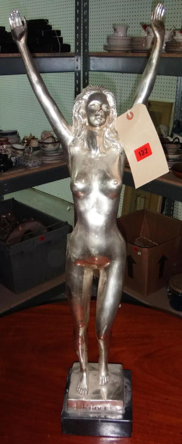 A 20th century chrome figure of a nude female with arms raised.