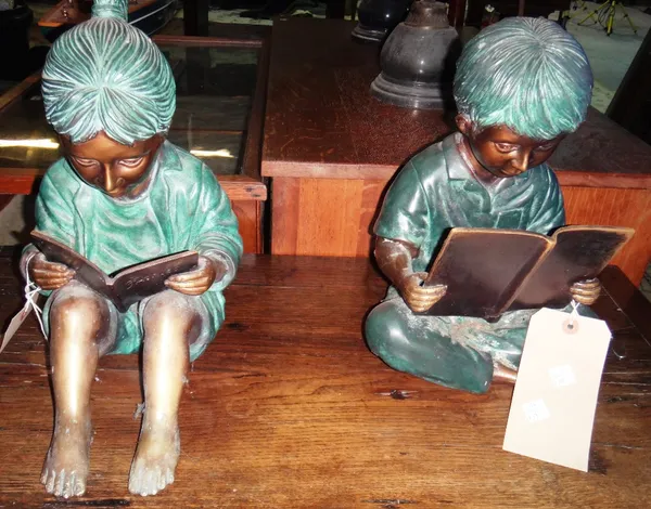 A 20th century bronze and green painted little girl reading, together with another similar of a boy reading.
