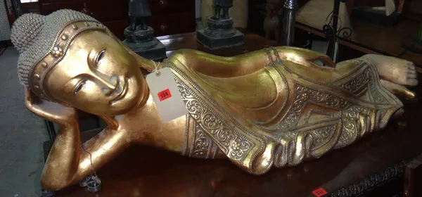 A 20th century gilt fibreglass model of a reclining Buddha.