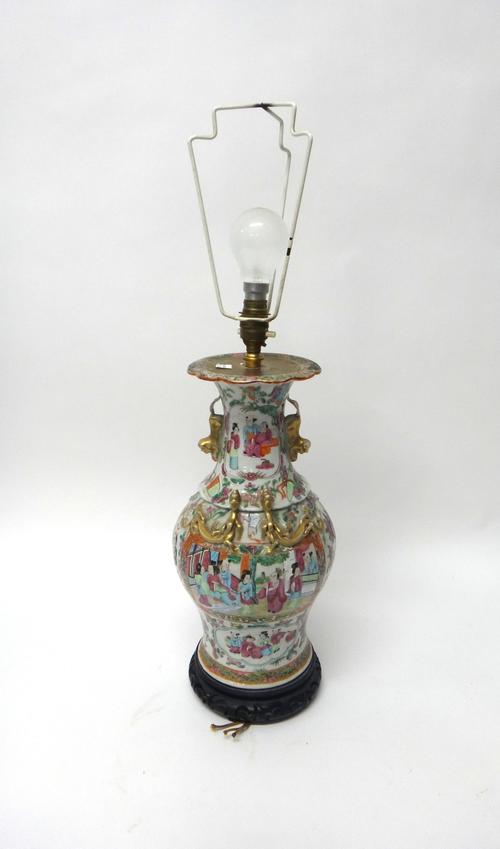 A Canton famille-rose baluster vase, 19th century, painted with figurative panels, the shoulders and neck applied with gilt chilong and buddhist lion