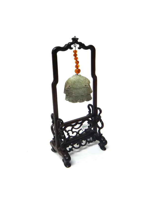A Chinese celadon jade pendant, Ming Dynasty, carved as a three tier canopy suspended by a wire strung with six amber beads from a later carved and pi