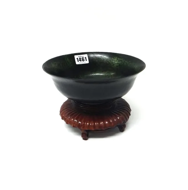 A spinach jade bowl, 20th century, with everted rim, 19cm.diameter, wood stand.