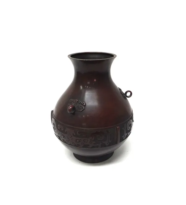 A Chinese archaic style bronze pear shaped vase, circa 1900, decorated with a band of taotie masks, beneath taotie mask and ring handles, signed,  34c