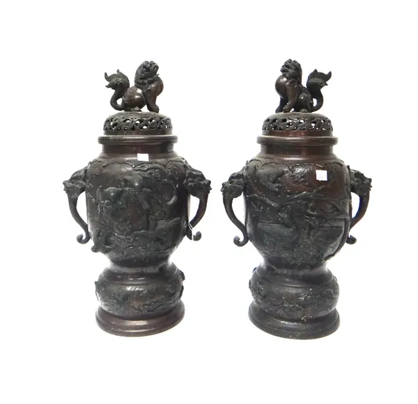 A pair of Japanese bronze vases and covers, Meiji period, set with animal mask handles, each body decorated in high relief with birds in branches, the