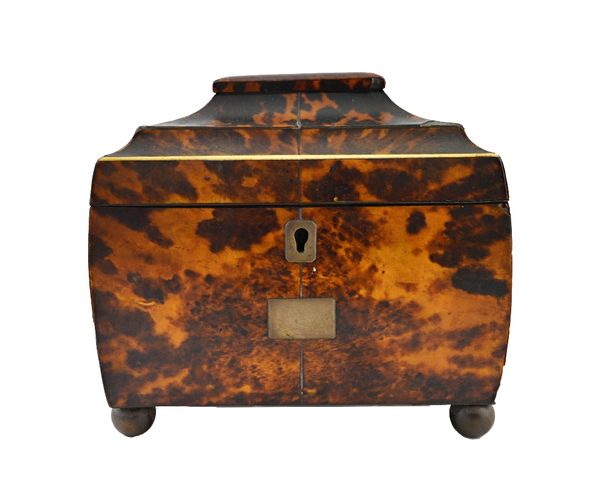 A George III tortoiseshell tea caddy with twin lidded interior, on bun feet, 16cm wide.  Illustrated