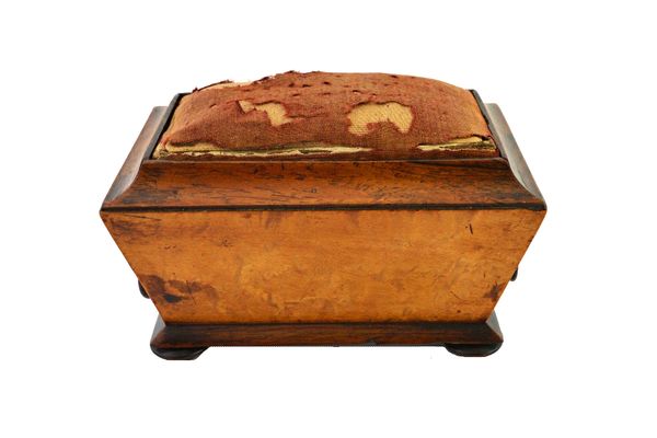 A 19th century sarcophagus shaped birds eye maple and rosewood pin cushion, with single drawer, on bun feet, 15cm wide.  Illustrated