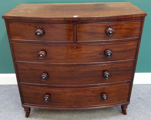 An early 19th century mahogany bowfront chest of two short and three long graduated drawers on splayed turned feet, 99cm wide.