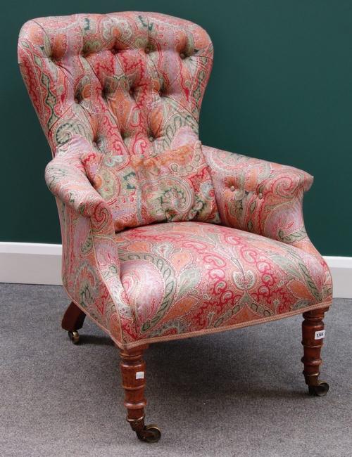 An early Victorian button back easy armchair on turned mahogany supports.