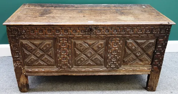 A 17th century and later oak coffer, the plank top over a geometric carved triple panel front on stile feet, 120cm wide.
