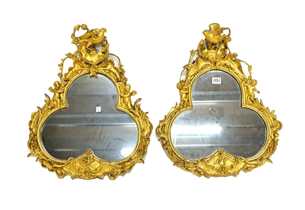 A pair of 19th century gilt framed wall mirrors, each with song bird crest over a quatrefoil mirror plate, in a surround of cherubs amongst acanthus s