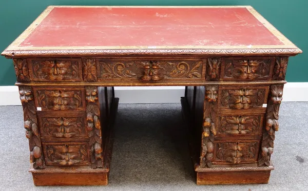 A 19th century carved oak writing desk with nine drawers about the knee, 123cm wide.