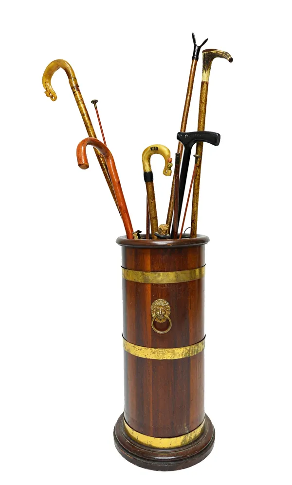 A 19th century brass bound coopered mahogany circular stick stand, with lion ring handles, on a stepped base, 65cm high.  Illustrated