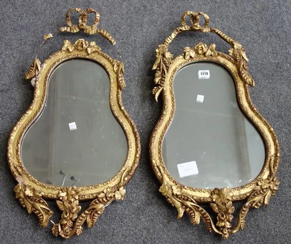 A pair of 19th century gilt framed wall mirrors, with ribbon tied crest over shaped mirror plate, 37cm wide x 70cm high.