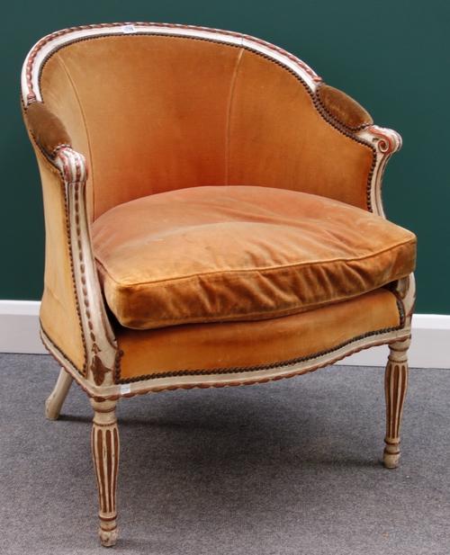 A Louis XV style cream painted parcel gilt tub back fauteuil, with serpentine seat on fluted baluster supports.