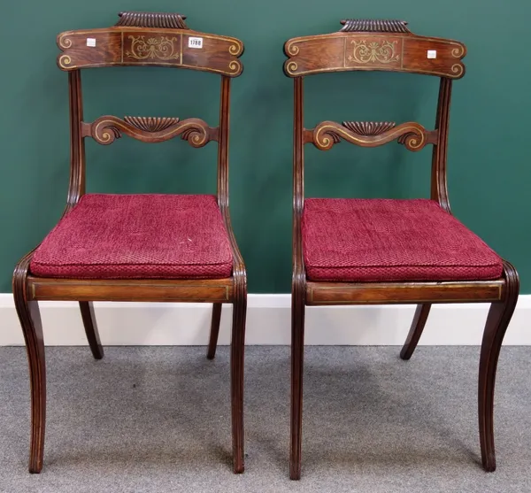 A set of four Regency brass inlaid rosewood dining chairs, with gadrooned crest and waist rail on sabre supports. (4)