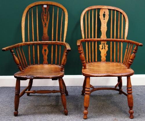 An early 19th century ash and elm Windsor chair with pierced splat and turned supports, together with another similar. (2)