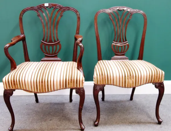 A matched set of twelve mahogany framed dining chairs with pierced splat and serpentine seat on cabriole supports to include a pair of carvers, eight