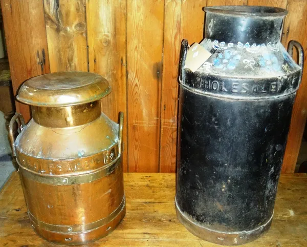 A copper lidded milk churn together with a black painted milk churn.