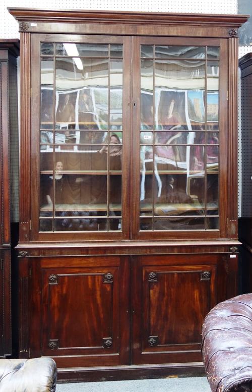 A George III mahogany bookcase cabinet, the pair of astragal glazed doors over a pair of panel cupboards, on plinth base, 161cm wide x 244cm high.