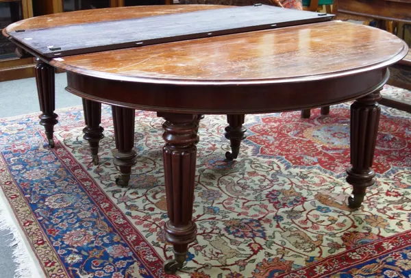 A Victorian mahogany circular extending dining table on eight tapering reeded supports, to include two extra leaves, 143cm wide x 257cm extended (this