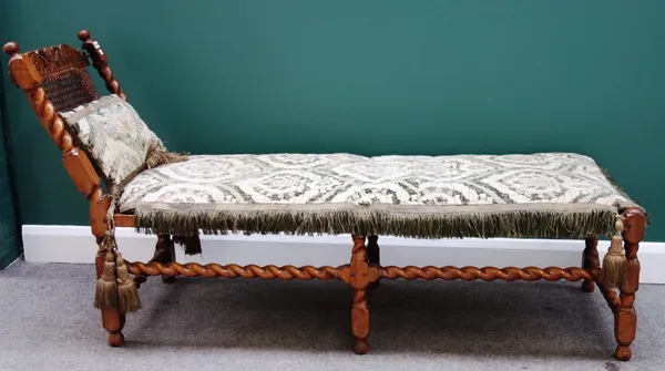 A William and Mary carved walnut framed cane upholstered day bed on barley-twist supports, 180cm wide.