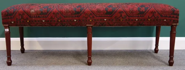 A large rectangular footstool with carpet upholstered seat, on six turned mahogany supports, 155cm wide.