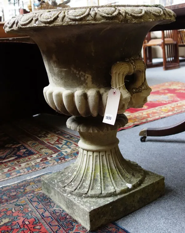 A reconstituted stone jardiniere, with pair of face mask handles and semi fluted body, on fluted turned socle, together with a reconstituted stone jar