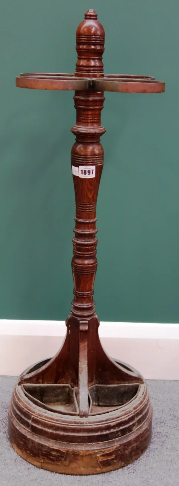 A Victorian oak and metal mounted four division stick stand, with turned column and stepped circular base, 86cm high.