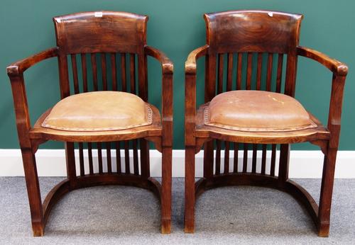 In the manner of Josef Hoffmann; a pair of early 20th century Arts and Crafts design hardwood framed tub back open armchairs.