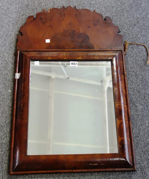 A 20th century William and Mary style walnut and yew wood oyster veneered cushion framed wall mirror, with fret carved upper frieze, 47cm wide x 87cm