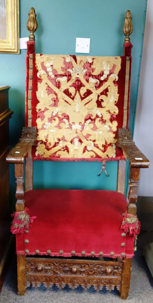 A pair of 19th century and earlier Spanish walnut framed open arm throne chairs, with gilt finials and carved lower frieze, each 158cm high.
