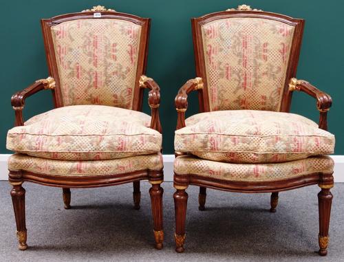 A set of four late 18th century Italian parcel gilt walnut framed open armchairs, with serpentine seats on tapering fluted supports.