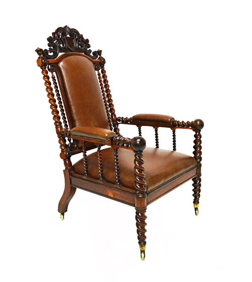 A Victorian rosewood framed semi-padded open arm easy chair, with pierced and carved crest, on extensive barley-twist supports.  Illustrated
