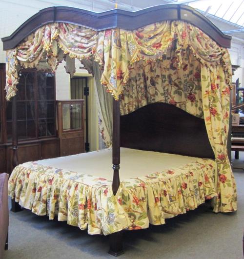 A 20th century hardwood four poster bed, with turned and fluted foot board supports, 183cm wide x 214cm long.