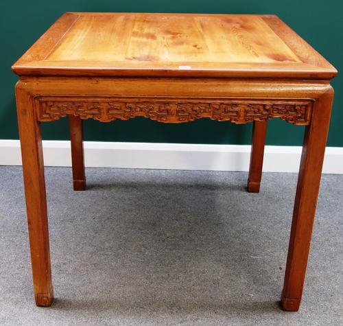 An early 20th century Chinese hard and soft wood square centre table with carved frieze, on block supports, 95cm wide.