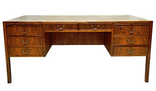 A 20th century rosewood free standing writing desk by Ole Wanscher with eight drawers about the arched knee, the opposing side with recess, two short