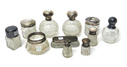 A silver topped faceted glass scent bottle, Chester 1921, a silver topped faceted glass hair tidy jar, Chester 1908, a silver and enamel topped smelli